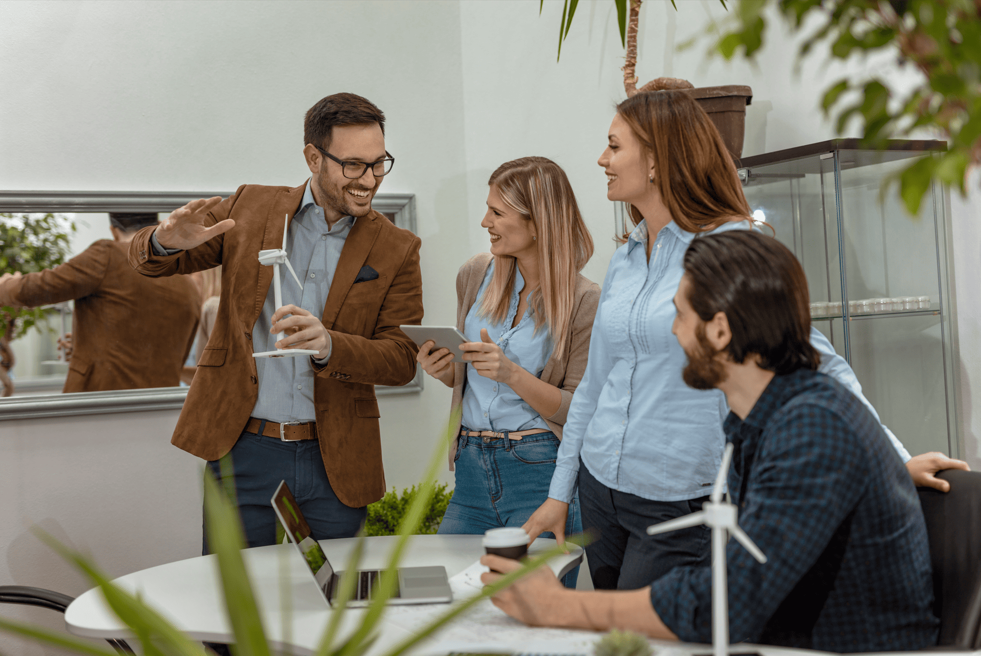 Equipe discutindo projeto de energia alternativa com modelo de turbina eólica